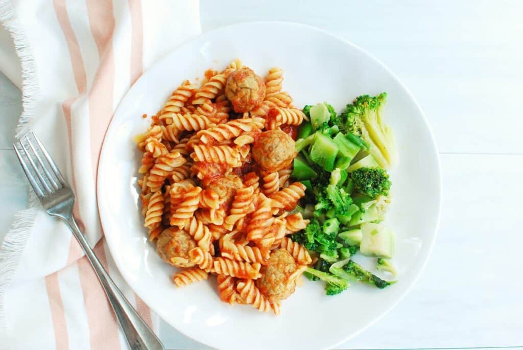 Pasta with a side of broccoli.