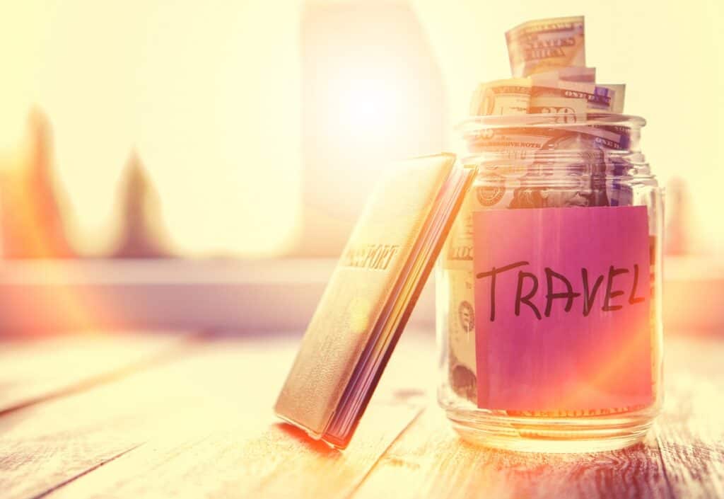 A jar labeled travel with money being saved for a trip.
