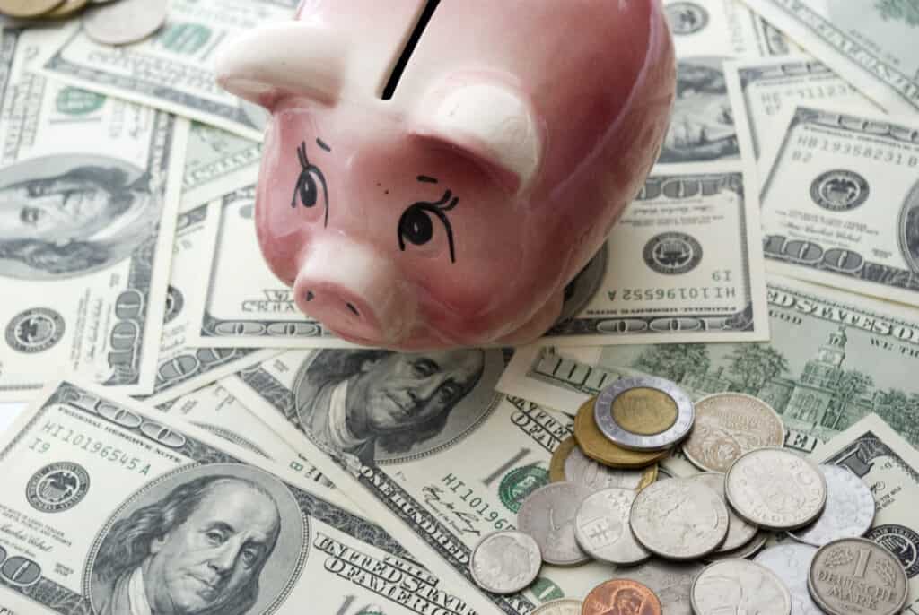 A piggy bank sitting on money.