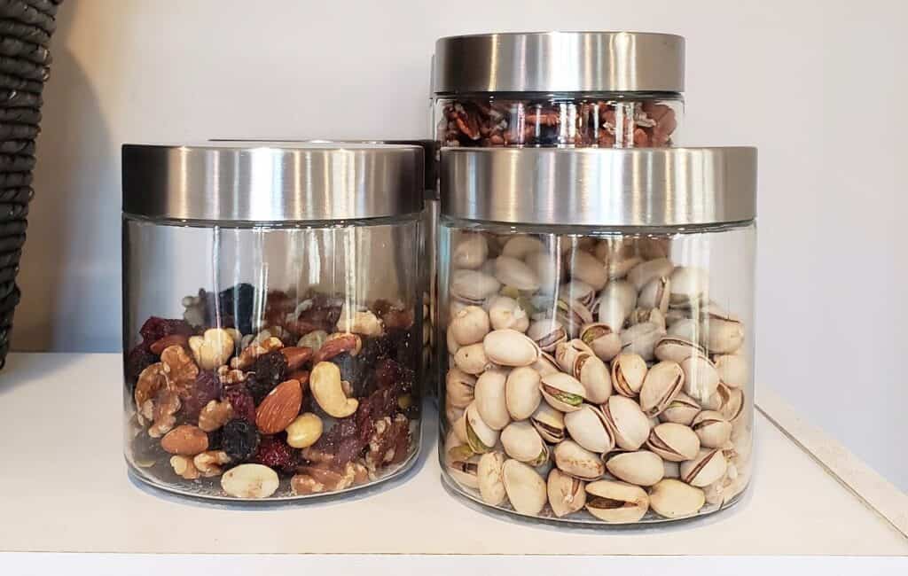 Nuts organized in Dollar Tree glass canisters.